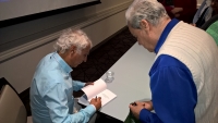 Dr Michael Salla signing his book for Dudley Robb